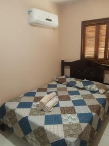 a bed with a blue and white blanket and a fan at Conforto e comodidade em Santa Maria in Santa Maria