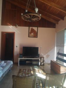 ein Wohnzimmer mit einem Flachbild-TV und einem Sofa in der Unterkunft Conforto e comodidade em Santa Maria in Santa Maria