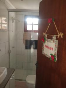 a bathroom with a toilet and a door with a sign on it at Conforto e comodidade em Santa Maria in Santa Maria