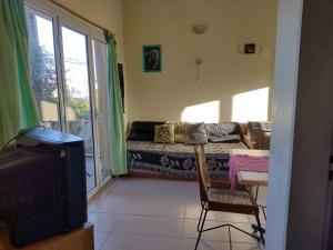 - un salon avec un canapé, une table et une télévision dans l'établissement OASIS PA CLAU, à Las Grutas