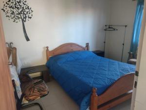 - une chambre avec un lit et une couette bleue dans l'établissement OASIS PA CLAU, à Las Grutas