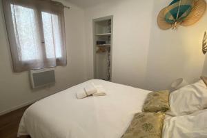 a white bed with two towels on top of it at * Logement Haut de gamme Centre * in Perpignan