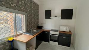 a small kitchen with a sink and a window at RÉSIDENCE MEUBLÉE 1ERE CLASSE DOUALA pk 15 in Douala