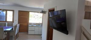 a flat screen tv hanging on a wall in a kitchen at El cielo en Purmamarca in Purmamarca