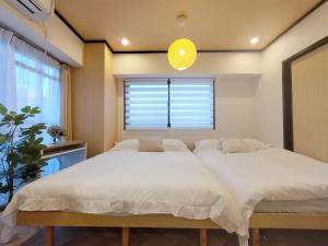 a bedroom with a large white bed with a window at Classic/modern Japanese-style 2rooms/3mins to Sta/8P in Tokyo