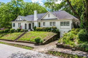 une maison blanche avec un jardin en face dans l'établissement East Point Luxury, à Atlanta