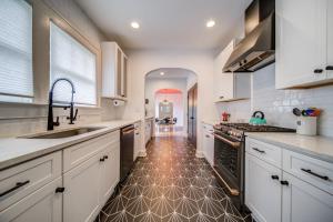 a large kitchen with white cabinets and a tile floor at East Point Luxury in Atlanta