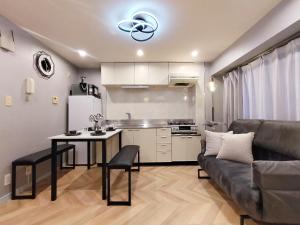 a kitchen and a living room with a couch and a table at Classic/modern Japanese-style 2rooms/3mins to Sta/8P in Tokyo
