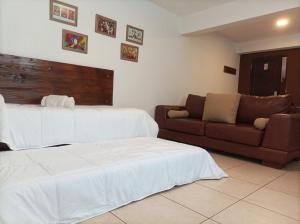 Habitación de hotel con 2 camas y sofá en Carnaval p/6 - 2 dorm - Amplio y a 5' del centro en Salta