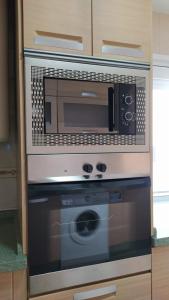 a microwave oven sitting inside of a kitchen at Sherryflat Claveles - Parking in Jerez de la Frontera