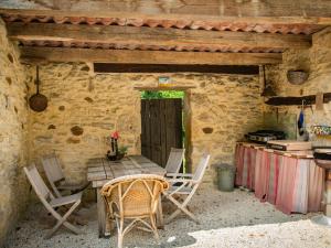 un tavolo e sedie all'aperto in una casa in pietra di Loupiac 8pers a Puy-lʼÉvêque