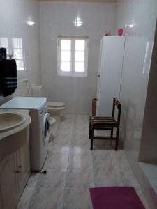 ein Bad mit einem WC, einem Waschbecken und einem Kühlschrank in der Unterkunft Férias felizes em família/com amigos 