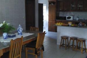 eine Küche mit einem Tisch, Stühlen und einer Theke in der Unterkunft Férias felizes em família/com amigos 