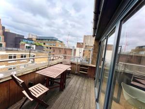 uma varanda com uma mesa e cadeiras num edifício em London Duplex Apartment 2 bedroom with Terrace em Londres