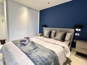 um quarto com uma cama grande e uma parede azul em London Duplex Apartment 2 bedroom with Terrace em Londres