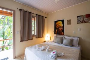 a bedroom with a bed with a painting of a woman at Espaço Rural Sítio Do Sol in Guabiruba