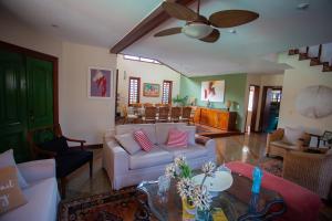uma sala de estar com um sofá e uma mesa em Casa a 50m da Praia de Itacoatiara Niteroi RJ em Niterói
