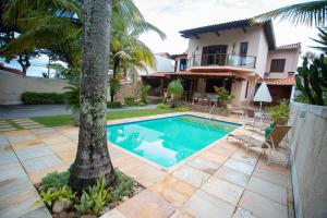 uma casa com uma piscina ao lado de uma palmeira em Casa a 50m da Praia de Itacoatiara Niteroi RJ em Niterói
