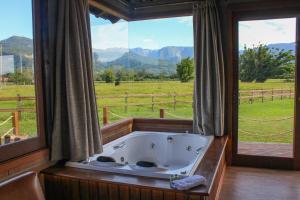 a bath tub in a room with a large window at Mirador da Montanha in Praia Grande