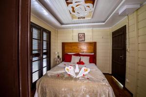 a bedroom with a bed with two birds on it at Espaço Rural Sítio Do Sol in Guabiruba