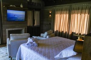 a bedroom with a bed and a tv on a wall at Mirador da Montanha in Praia Grande