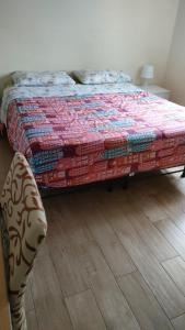 1 dormitorio con 1 cama y suelo de madera en De Candia House, en Rescaldina