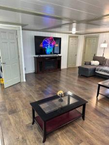 een woonkamer met een tafel en een tv bij Hot Tub 5 beds in Moorhead