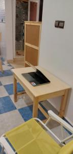einen Holztisch mit einem Laptop darüber in der Unterkunft Repos Surf House 1 in Sidi Ifni
