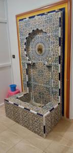 eine Dusche in einem Zimmer mit Mosaikwand in der Unterkunft Repos Surf House 1 in Sidi Ifni
