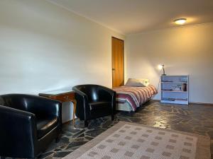 1 dormitorio con 1 cama, escritorio y 2 sillas en Glengarry, en Jindabyne