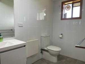 Baño blanco con aseo y lavamanos en Glengarry, en Jindabyne