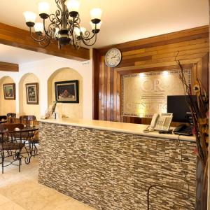 a bar in a restaurant with a clock on the wall at Quinta Roca Hotel in Oaxaca City