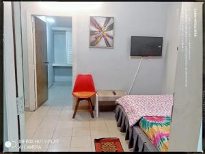 Zimmer mit einem Bett und einem roten Stuhl in der Unterkunft Hotel Arcane in Cox's Bazar