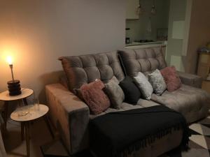 um sofá com almofadas na sala de estar em Apartamento La Vista em Gramado