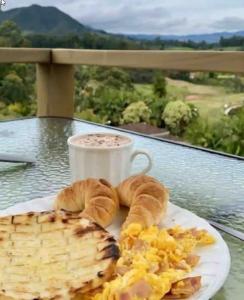 einen Teller mit Frühstücksspeise und eine Tasse Kaffee in der Unterkunft Alto Paraíso Glamping Carmen de Viboral in Rionegro