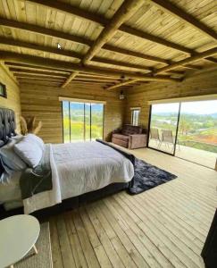 ein Schlafzimmer mit einem großen Bett in einem Holzhaus in der Unterkunft Alto Paraíso Glamping Carmen de Viboral in Rionegro