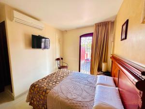 a hotel room with a bed and a window at Hotel Quinta Roca in Oaxaca City