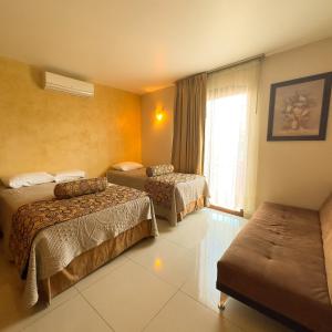 Habitación de hotel con 2 camas y ventana en Quinta Roca Hotel, en Oaxaca City