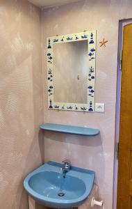 La salle de bains est pourvue d'un lavabo bleu et d'un miroir. dans l'établissement L'estaminet De La Vallée, à Schwartzbach