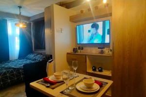 a living room with a table and a tv in a room at Blk Pod in Punta