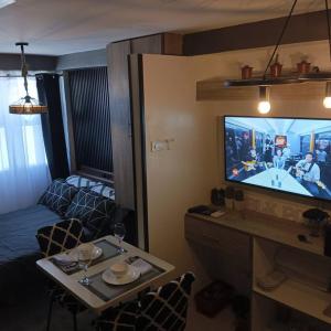 a living room with a television and a table with chairs at Blk Pod in Punta