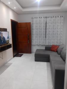 a living room with a couch and a tv at Casa grande em arapongas in Arapongas