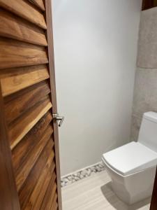 łazienka z toaletą i drewnianymi drzwiami w obiekcie Casa Ak’ab’al Bacalar w mieście Bacalar