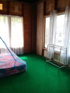 een kamer met een bed en een groene vloer bij Purabarang Homestay in Rantepao