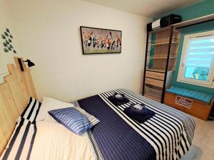 a bedroom with a bed and a picture on the wall at Pretty apartment with a terrace near a sandy beach in Saint-Nic