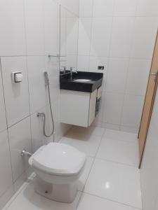 a white bathroom with a toilet and a sink at Casa grande em arapongas in Arapongas +28 photos