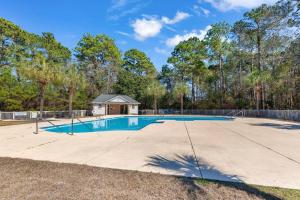 a swimming pool with a house in the background at Beach Place at True Blue - Close to the beach! in Pawleys Island