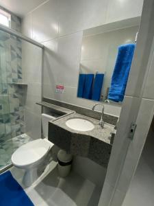 een badkamer met een toilet, een wastafel en een spiegel bij Suíte com banheiro privativo em Pousada recém construída,a 500mts do pátio do forró in Caruaru