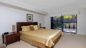 een slaapkamer met een groot bed en een groot raam bij Luro 2 - Waterfront Luxury in Ettalong Beach
