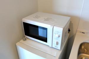eine Mikrowelle auf einem Kühlschrank in der Unterkunft オリエントシティ南堀江Ⅱ in Osaka